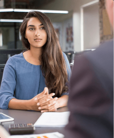 A woman sitting at a table with another person.