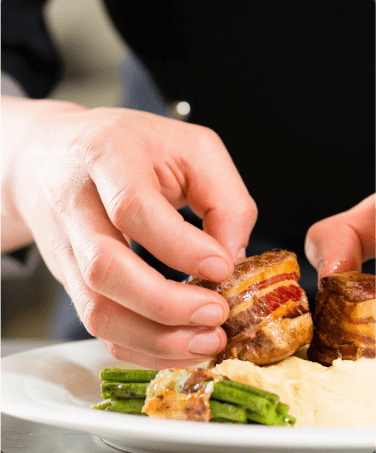 A person is holding food on top of a plate.