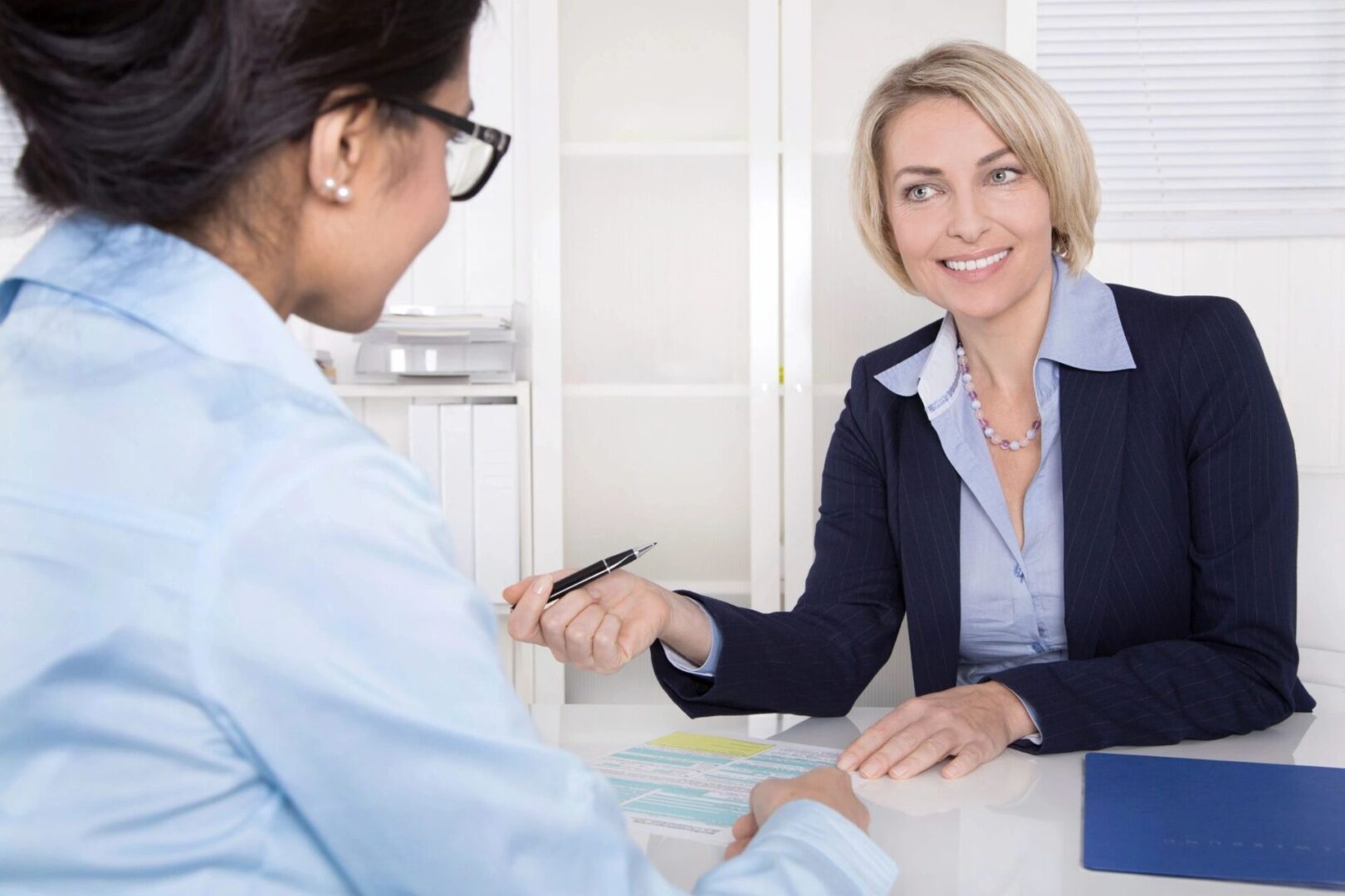 A woman is holding her hand out to another person.