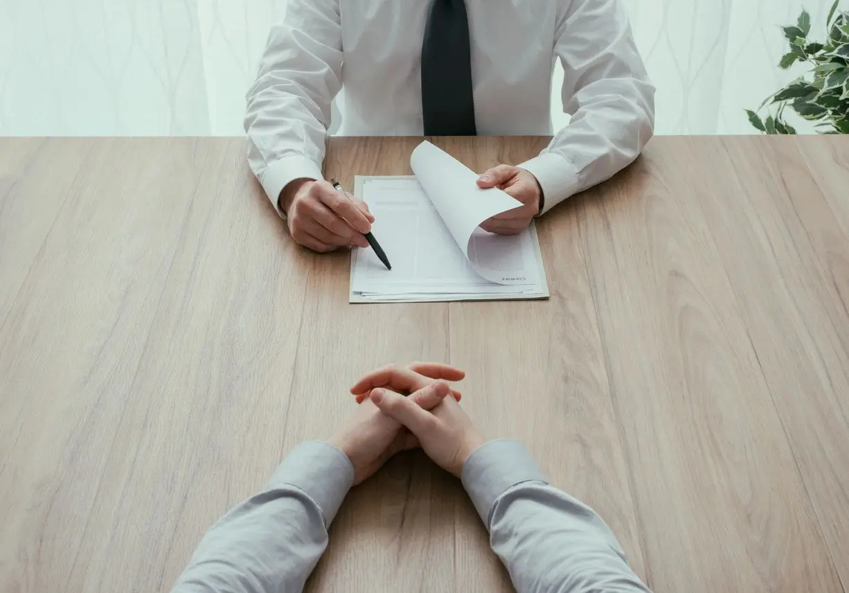 A man is interviewing someone on the table