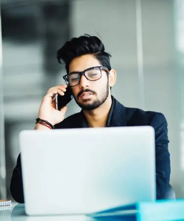 A man sitting at his desk on the phone